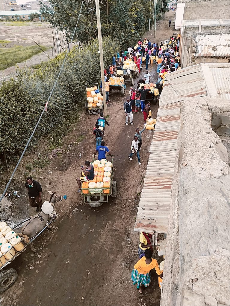 Community members in Kayole, Nairobi Kenya lining up at a water selling point during the COVID-19 pandemic.